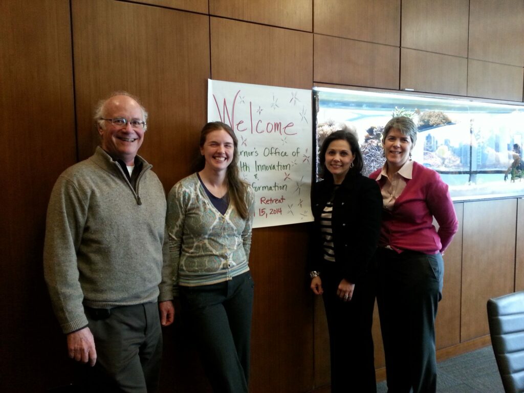 Retreat participants smile in a conference room